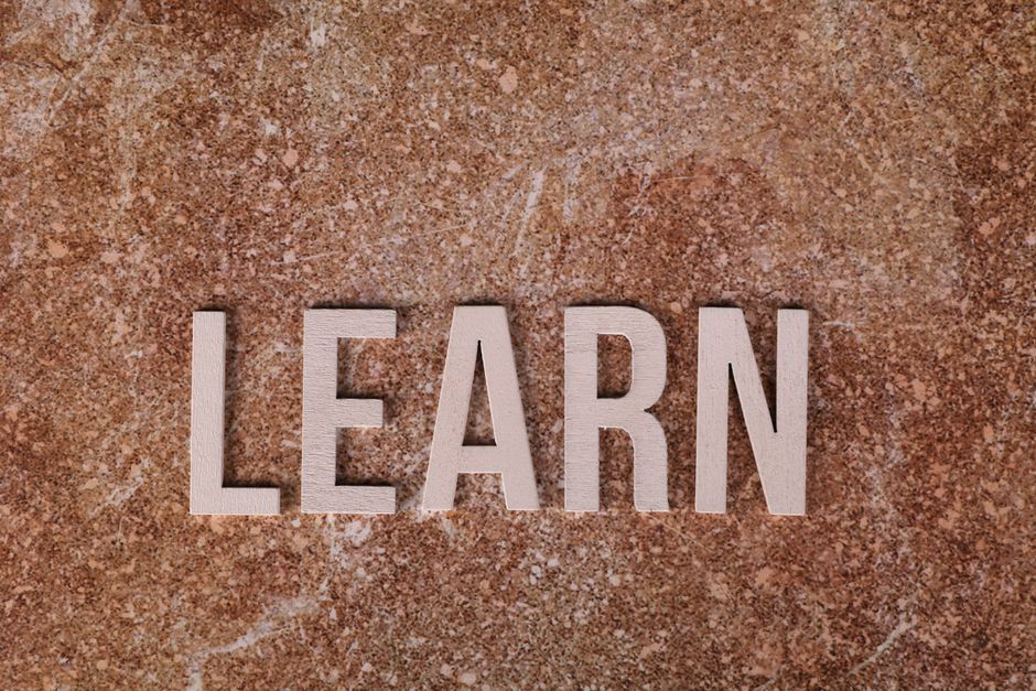 Wooden letters spelling 'Learn' on a textured marble surface, symbolizing education and growth.